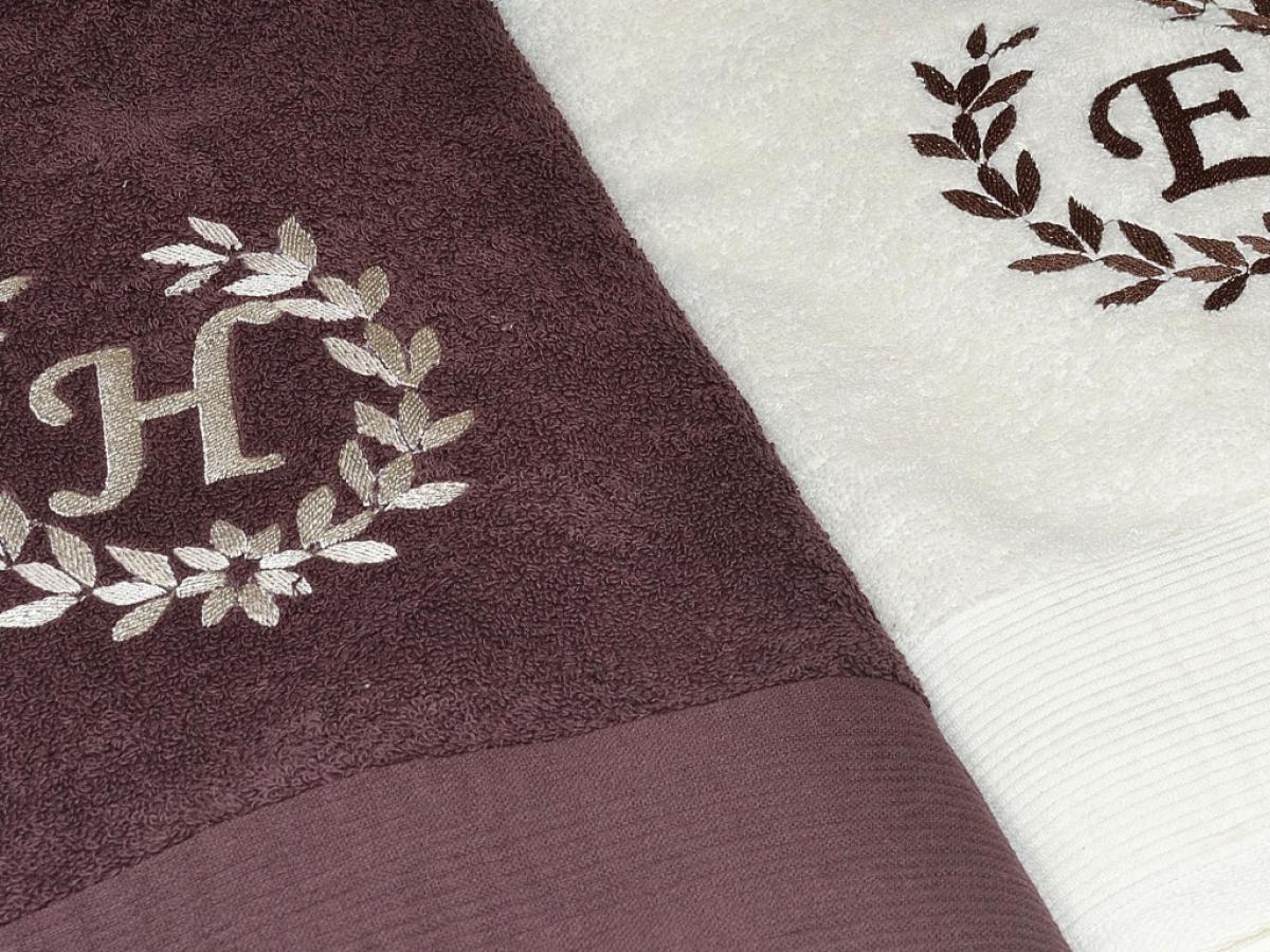 Kremowy i brązowy ręcznik z wyszytym monogramem. Na kremowym ręczniku nitka brązowa , na brązowym ręczniku nitka kremowa